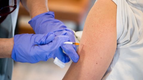 Person bekommt AstraZeneca Impfstoff in Arm