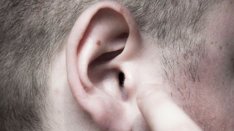 Nahaufnahme eines Ohres: Das Ohr ist nicht nur fürs Hören zuständig. Es ist auch für den Gleichgewichtssinn von zentraler Bedeutung, denn im Innenohr befindet sich das Vestibularorgan zur Steuerung des Gleichgewichts.