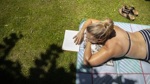Sonnenbaden mit Buch: 80 bis 90 Prozent an Vitamin D bildet der Körper in der Haut selbst - allerdings nur bei direkter Sonnenbestrahlung und ohne Verwendung einer Sonnencreme
