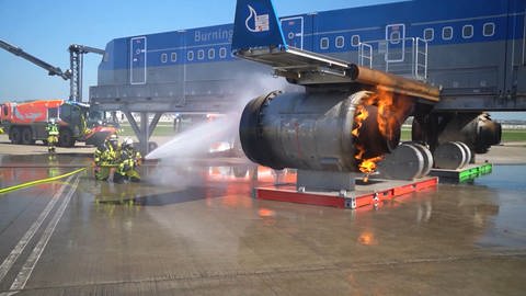 Brandbekämpfer löschen ein Triebwerk der Brandsimulationsanlage am Flughafen Stuttgart