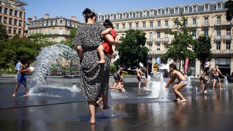 Rekordtemperaturen in Toulouse, aufgrund einer Hitzewelle Kinder spielen während in Toulouse in Wasserdüsen.