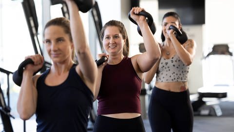 Ein Krafttraining pro Woche bringt bei Frauen so viel für die Gesundheit, wie dreimal Trainieren bei Männern. Das zeigt eine neue Studie. Frauen beim Krafttraining im Fitnesstudio.